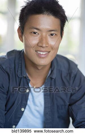 Stock Photography - Korean man smiling indoors. Fotosearch