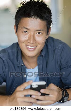 Korean man using cell phone View Large Photo Image Stock Photograph - Korean man using cell phone. Fotosearch