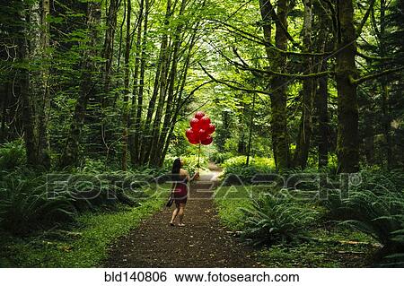 Korean woman holding red balloons in lush forest View Large Photo Image Stock Photograph - Korean woman holding red balloons in lush forest. Fotosearch
