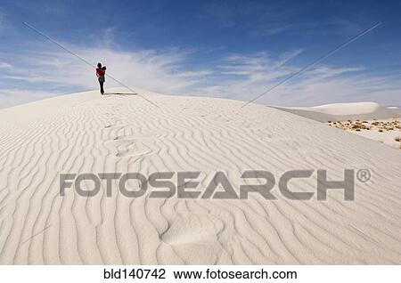 Man climbing sand dune in desert View Large Photo Image Stock Image - Man climbing sand dune in desert. Fotosearch