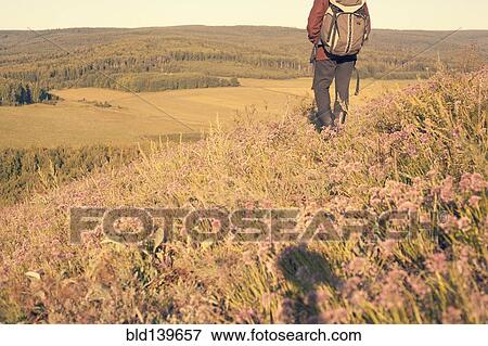 Mari man carrying backpack in rural field View Large Photo Image Stock Photo - Mari man carrying backpack in rural field. Fotosearch