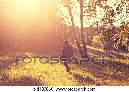 Stock Photograph - Mari man carrying backpack in rural field. Fotosearch