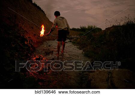Mari man holding torch in rural creek View Large Photo Image Stock Photograph - Mari man holding torch in rural creek. Fotosearch