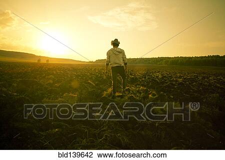 Stock Image - Mari man standing in rural field. Fotosearch