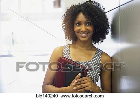 Mixed race businesswoman carrying digital tablet View Large Photo Image Stock Image - Mixed race businesswoman carrying digital tablet. Fotosearch