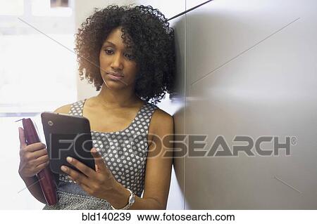 Stock Photo - Mixed race businesswoman using digital tablet. Fotosearch