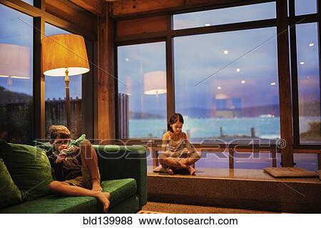 Mixed race children using cell phones in living room View Large Photo Image Stock Photo - Mixed race children using cell phones in living room. Fotosearch