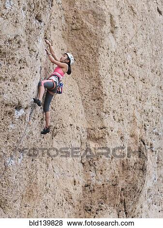 Mixed race girl climbing steep cliff View Large Photo Image Stock Photo - Mixed race girl climbing steep cliff. Fotosearch