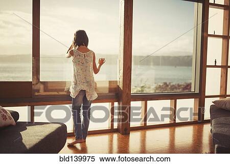 Mixed race girl looking out living room window View Large Photo Image Stock Photography - Mixed race girl looking out living room window. Fotosearch