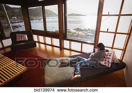 Mixed race girl using cell phone in modern living room View Large Photo Image Picture - Mixed race girl using cell phone in modern living room. Fotosearch