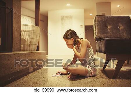 Mixed race girl using cell phone in living room View Large Photo Image Stock Image - Mixed race girl using cell phone in living room. Fotosearch