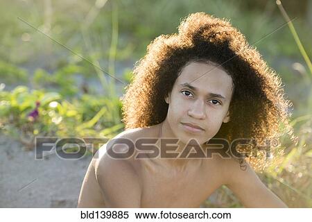 Mixed race teenage boy sitting on beach View Large Photo Image Stock Photography - Mixed race teenage boy sitting on beach. Fotosearch