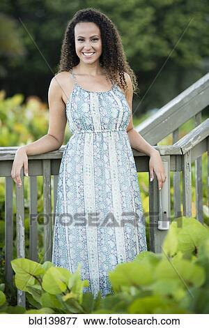 Mixed race woman leaning on wooden banister View Large Photo Image Stock Photo - Mixed race woman leaning on wooden banister. Fotosearch