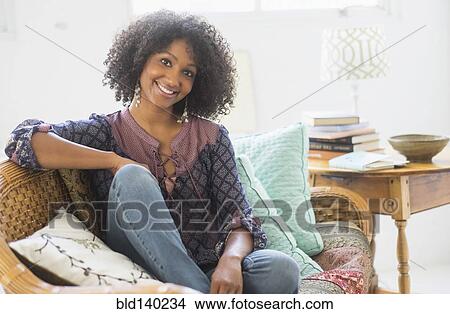Mixed race woman smiling in living room View Large Photo Image Picture - Mixed race woman smiling in living room. Fotosearch