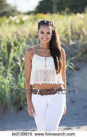 Stock Photography - Mixed race woman smiling on beach. Fotosearch