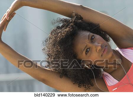 Stock Photo - Mixed race woman stretching arms. Fotosearch