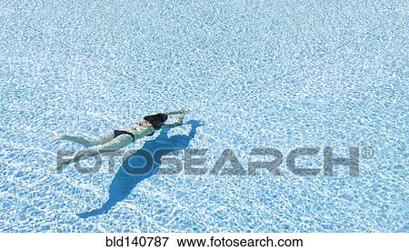 Mixed race woman swimming in clear water View Large Photo Image Stock Photo - Mixed race woman swimming in clear water. Fotosearch