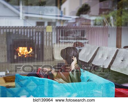 Picture - Mixed race woman using digital tablet in living room. Fotosearch