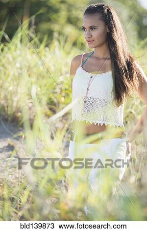 Mixed race woman walking in tall grass View Large Photo Image Stock Image - Mixed race woman walking in tall grass. Fotosearch
