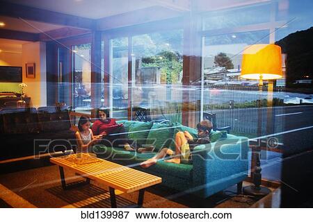 Stock Photo - Mother and children relaxing together in modern living room. Fotosearch
