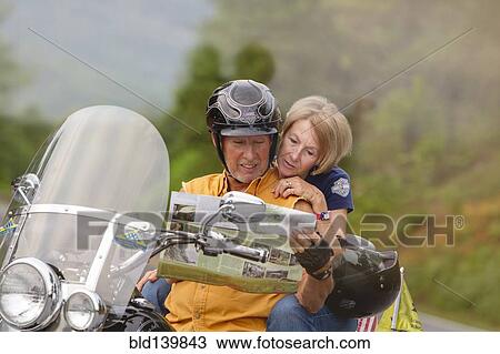 Older Caucasian couple reading map on motorcycle View Large Photo Image Stock Image - Older Caucasian couple reading map on motorcycle. Fotosearch