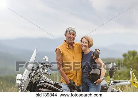 Picture - Older Caucasian couple smiling on motorcycle. Fotosearch