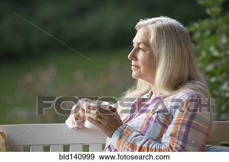 Older Caucasian woman drinking cup of coffee on porch swing View Large Photo Image Stock Photo - Older Caucasian woman drinking cup of coffee on porch swing. Fotosearch