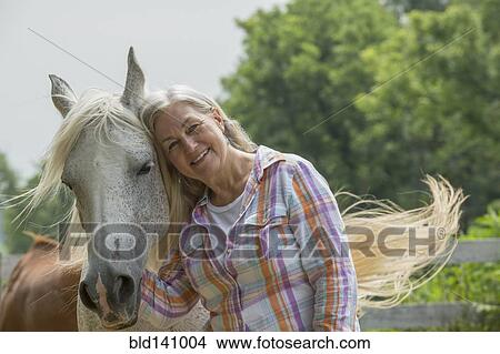 Older Caucasian woman petting horse outdoors View Large Photo Image Picture - Older Caucasian woman petting horse outdoors. Fotosearch
