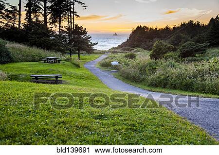 Stock Image - Path in park overlooking sunset and ocean. Fotosearch
