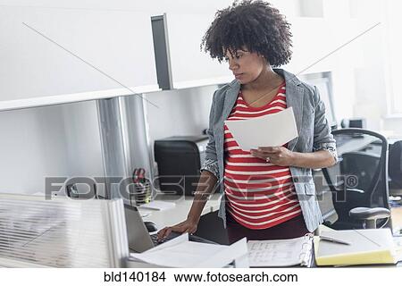 Pregnant African American businesswoman working in office View Large Photo Image Picture - Pregnant African American businesswoman working in office. Fotosearch