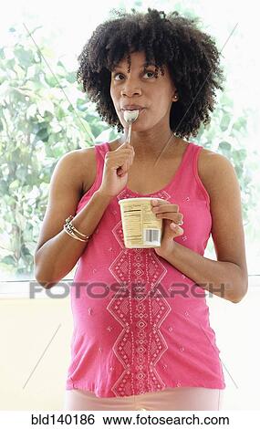 Pregnant African American mother eating ice cream from carton View Large Photo Image Stock Photograph - Pregnant African American mother eating ice cream from carton. Fotosearch