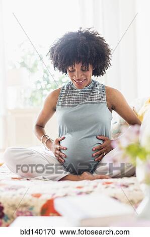 Pregnant African American mother holding her stomach View Large Photo Image Stock Image - Pregnant African American mother holding her stomach. Fotosearch