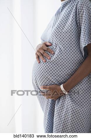 Pregnant African American mother holding her belly in hospital View Large Photo Image Stock Image - Pregnant African American mother holding her belly in hospital. Fotosearch