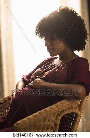 Pregnant African American mother holding her stomach View Large Photo Image Stock Photo - Pregnant African American mother holding her stomach. Fotosearch
