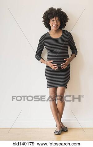 Pregnant African American mother holding her stomach View Large Photo Image Stock Photo - Pregnant African American mother holding her stomach. Fotosearch