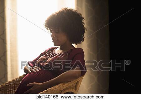 Pregnant African American mother holding her stomach View Large Photo Image Stock Photograph - Pregnant African American mother holding her stomach. Fotosearch