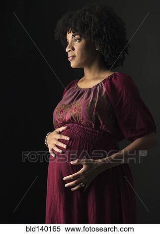 Pregnant African American mother holding her stomach View Large Photo Image Stock Photography - Pregnant African American mother holding her stomach. Fotosearch