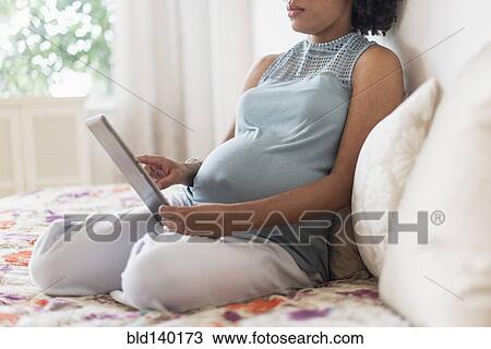 Pregnant African American mother using digital tablet in bed View Large Photo Image Stock Image - Pregnant African American mother using digital tablet in bed. Fotosearch