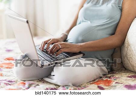 Pregnant African American mother using laptop computer in bed View Large Photo Image Stock Photography - Pregnant African American mother using laptop computer in bed. Fotosearch