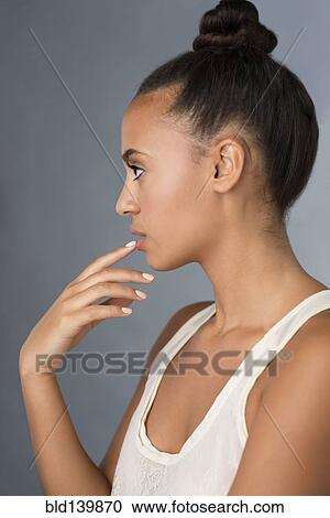 Profile of mixed race woman touching her lip View Large Photo Image Stock Image - Profile of mixed race woman touching her lip. Fotosearch