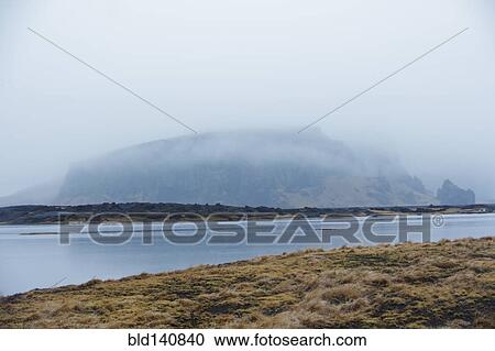 Stock Image - River near misty remote mountain. Fotosearch