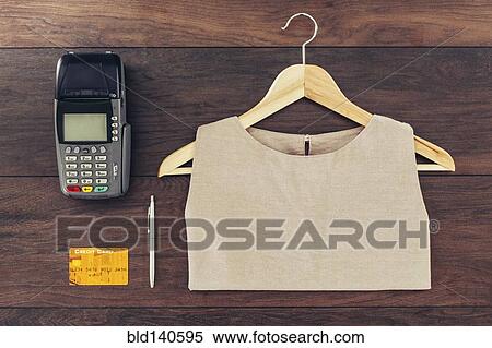 Shirt on hanger, credit card and machine on store counter View Large Photo Image Stock Photography - Shirt on hanger, credit card and machine on store counter. Fotosearch