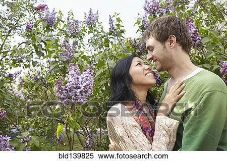 Smiling couple hugging in park View Large Photo Image Stock Photography - Smiling couple hugging in park. Fotosearch