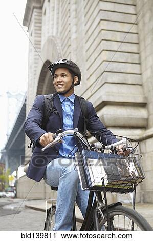 Smiling man riding bicycle on city street View Large Photo Image Stock Image - Smiling man riding bicycle on city street. Fotosearch