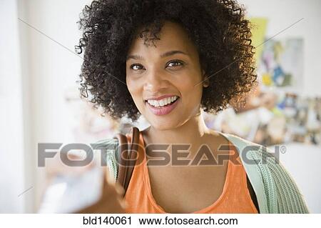 Stock Image - Smiling woman paying with credit card. Fotosearch