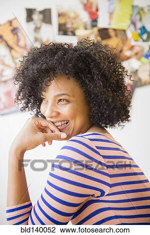 Stock Image - Smiling woman resting chin in hand. Fotosearch