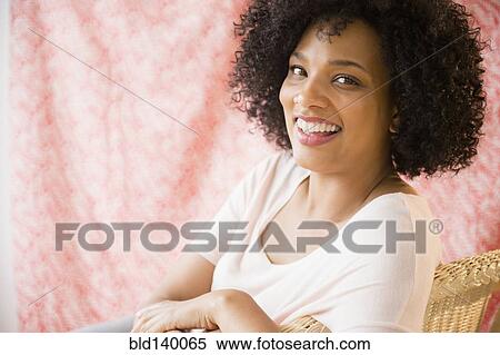 Smiling woman sitting in chair View Large Photo Image Stock Photography - Smiling woman sitting in chair. Fotosearch