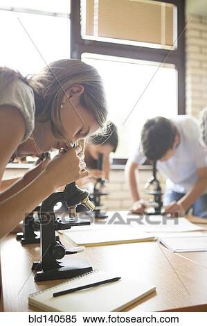 Stock Photography - Students using microscopes in science class. Fotosearch