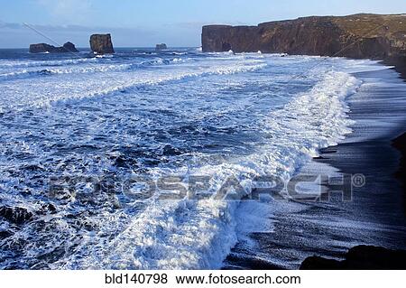 Waves washing up by rocky cliffs on beach View Large Photo Image Stock Photo - Waves washing up by rocky cliffs on beach. Fotosearch