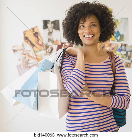 Stock Image - Woman carrying shopping bags. Fotosearch